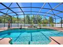 Sparkling pool with a screened enclosure and a serene outdoor setting at 2629 Maggiore Cir, Kissimmee, FL 34746