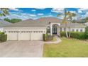 Inviting single-story home featuring a three-car garage, lush lawn, and well-maintained landscaping at 2877 Ashton Ter, Oviedo, FL 32765