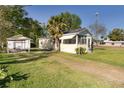 Side view of the charming home with a detached garage and a spacious yard at 311 E Wallace St, Orlando, FL 32809