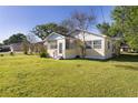 Cozy home featuring a screened porch and a lush green lawn at 311 E Wallace St, Orlando, FL 32809