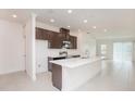 Modern kitchen with dark wood cabinets, stainless steel appliances, and a large white quartz island at 4176 Sagefield Dr, Harmony, FL 34773
