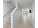 Bright hallway features tile flooring, stairway to the second floor and access to the living area at 435 Tradition Ln, Winter Springs, FL 32708