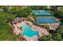 Aerial view of the community pool with a separate hot tub and tennis and basketball courts nearby at 4536 Barrister Dr, Clermont, FL 34711