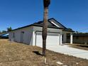 Side view of a charming white single-Gathering home with a garage, complemented by a clear blue sky at 4537 Conley St, Orlando, FL 32811