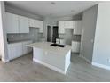 Bright kitchen featuring white cabinets, a center island with a sink, and modern fixtures creating a stylish space at 4537 Conley St, Orlando, FL 32811