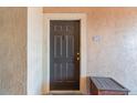 Condo entrance with dark door, door knocker, and wooden storage container at 5578 Metrowest Blvd # 310, Orlando, FL 32811