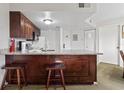 Efficient kitchen featuring granite countertops, dark wood cabinets, and a breakfast bar at 6403 Parc Corniche Dr # 4204, Orlando, FL 32821
