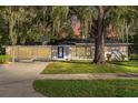 Charming single-story home featuring a blue front door, lush landscaping, and beautiful trees draped in Spanish moss at 719 Se 24Th St, Ocala, FL 34471