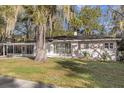 Charming single-story home featuring a blue front door, lush landscaping, and beautiful trees draped in Spanish moss at 719 Se 24Th St, Ocala, FL 34471