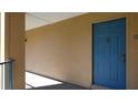 Exterior hallway featuring unit 12 with a blue door in a well-maintained building at 7230 Westpointe Blvd # 1222, Orlando, FL 32835
