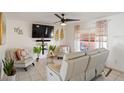 Bright living room featuring neutral tile floors, a modern ceiling fan and cozy seating at 825 Keats Ave, Orlando, FL 32809
