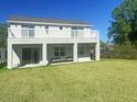 This home features a spacious backyard and a large, covered patio with an elevated second-story balcony at 827 Dennis Ave, Orlando, FL 32807