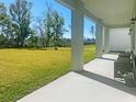 Covered patio with stylish seating and a large, lush backyard perfect for outdoor relaxation and entertaining at 827 Dennis Ave, Orlando, FL 32807