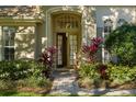 Inviting front entrance with double doors, surrounded by vibrant landscaping and a brick walkway at 8912 Heritage Bay Cir, Orlando, FL 32836