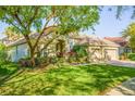 Beautiful single-story home with manicured lawn, garden, and mature shade tree at 8912 Heritage Bay Cir, Orlando, FL 32836