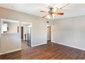 Open living room with wood-look floors, neutral walls, and a ceiling fan, leading to the kitchen at 1103 Timor Ave, Orlando, FL 32804