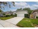 Well-maintained home featuring a two-car garage, manicured lawn, and trimmed hedges for curb appeal at 113 Golden Crest Ct, Winter Springs, FL 32708