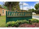 Liberty Oaks neighborhood sign with lush landscaping and green and gold sign at 1304 Independence Ln, Mount Dora, FL 32757