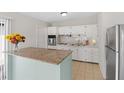 Bright kitchen featuring white cabinetry, granite countertops, and stainless steel refrigerator at 1633 Colton, Orlando, FL 32822