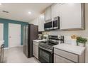 Modern kitchen featuring stainless steel appliances and sleek white cabinetry at 307 Corsica Ct, Kissimmee, FL 34758