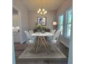 Elegant dining room featuring a marble table, modern chairs, chandelier, and natural light at 311 W Delaware Ave, Lake Helen, FL 32744