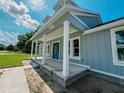 Attractive house featuring a welcoming covered porch and blue siding for a modern look at 311 W Delaware Ave, Lake Helen, FL 32744
