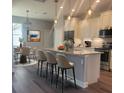 Open kitchen with an island, pendant lighting, modern appliances, and adjacent dining area at 311 W Delaware Ave, Lake Helen, FL 32744