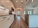 Modern kitchen featuring white cabinets, stainless steel appliances, and wood floors at 311 W Delaware Ave, Lake Helen, FL 32744