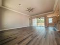 Spacious living room with wood-look floors, a ceiling fan, and sliding glass doors at 311 W Delaware Ave, Lake Helen, FL 32744