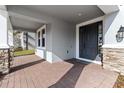 Inviting front porch featuring brick flooring, stone accents, and a stylish front door at 3121 Buffington Pl, Oviedo, FL 32765