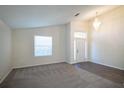 Inviting living room featuring neutral carpet, vaulted ceiling, and ample natural light from large windows at 3199 Quail Dr, Deltona, FL 32738