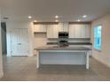 Bright kitchen featuring white cabinets, granite countertops, an island, and stainless steel appliances at 4152 Sagefield Dr, Harmony, FL 34773