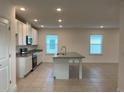Spacious kitchen featuring white cabinets, granite countertops, a center island, and stainless appliances at 4152 Sagefield Dr, Harmony, FL 34773
