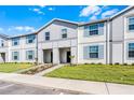 Well-maintained two-story townhome with modern facade, green lawn, and tidy landscaping at 4210 Lana Ave, Davenport, FL 33897