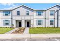 Charming two-story townhomes showcasing modern facades, manicured lawns, and inviting entrances at 4210 Lana Ave, Davenport, FL 33897