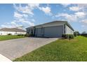 Attractive home with a brick driveway, well-maintained landscaping, and a spacious two-car garage at 4672 Marina Row Dr, Orlando, FL 32820