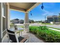 Cozy front porch view with seating area, showcasing the neighborhood street and blue skies at 5052 Blanchard Ct, St Cloud, FL 34772