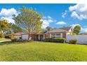 Well-maintained home featuring a brick facade, attached garage, and expansive, manicured lawn at 5263 Jade Cir, Belle Isle, FL 32812