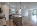 Bright, open kitchen with granite countertops, stainless steel appliances, and an island with pendant lighting at 5694 Aragon Ave, De Leon Springs, FL 32130