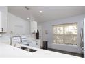 The well-lit kitchen offers stone countertops, white cabinetry and new appliances at 7 Sequoia Way, Kissimmee, FL 34758