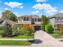 Charming two-story home with a well-maintained lawn, mature trees, and a wide driveway at 7945 Pleasant Pine Cir, Winter Park, FL 32792