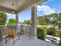 Covered front porch with seating, a view of landscaped yard, and a charming neighborhood setting at 7945 Pleasant Pine Cir, Winter Park, FL 32792