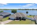 An aerial view showcases the house's proximity to a serene lake, with a well-maintained yard and a brick driveway at 130 Islabella Way, Groveland, FL 34736