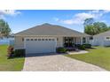 Charming single-story home with a paved driveway, two-car garage, and well-maintained lawn at 130 Islabella Way, Groveland, FL 34736