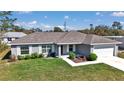 A charming one-story home with well-kept landscaping, gray exterior, and a two-car garage at 14978 Sw 24Th Cir, Ocala, FL 34473