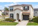 Charming two-story home featuring a well-manicured lawn, landscaped yard, and attached garage at 1799 Tropical Palms Cir, Kissimmee, FL 34747