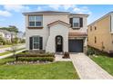 Charming two-story home featuring a well-manicured lawn, landscaped yard, and attached garage at 1799 Tropical Palms Cir, Kissimmee, FL 34747