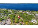 Aerial view shows proximity to lake and surrounding community, nestled within a canopy of trees at 208 Hideaway Ct, Minneola, FL 34715