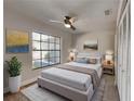 Cozy bedroom with a ceiling fan, large window with outdoor view, and neutral decor at 213 Almaden Ct, Winter Springs, FL 32708