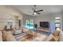 Inviting living room with comfortable seating, a ceiling fan, and a view of the pool area at 213 Almaden Ct, Winter Springs, FL 32708